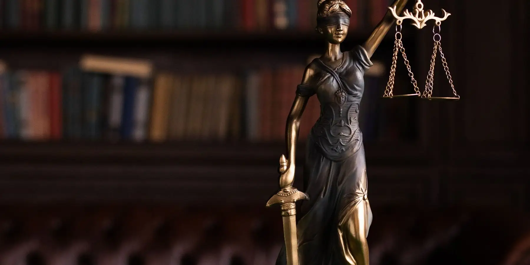 Estatua de la justicia y martillo sobre un escritorio